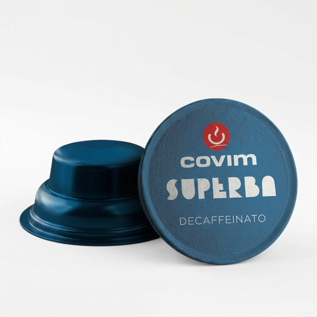 Dettaglio di due capsule Covim Superba Decaffeinato: entrambe caratterizzate da corpo e pellicola di colore blu metallizzato, con una vista di profilo e l'altra dall'alto.
