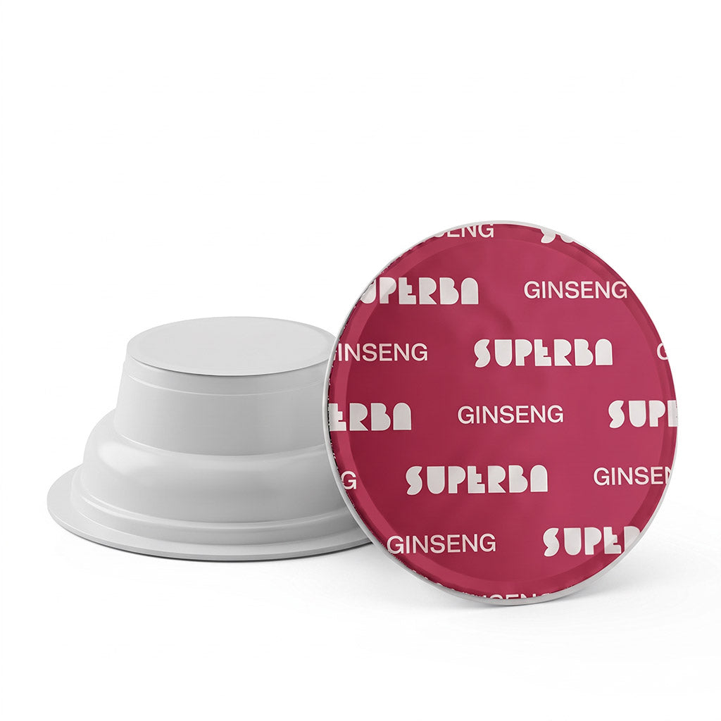 Dettaglio di due capsule Covim Superba Ginseng: una mostrata di profilo con corpo bianco e l'altra vista dall'alto con pellicola rosso fragola/magenta e scritte bianche.