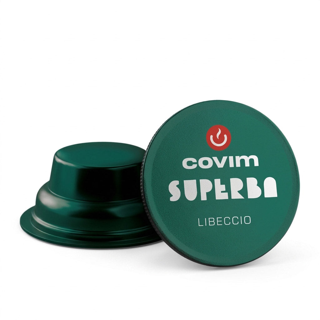 Dettaglio di due capsule Covim Superba Libeccio: entrambe caratterizzate da corpo e pellicola di colore verde scuro metallizzato, con una vista di profilo e l'altra dall'alto.