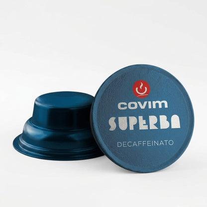Dettaglio di due capsule Covim Superba Decaffeinato: entrambe caratterizzate da corpo e pellicola di colore blu metallizzato, con una vista di profilo e l'altra dall'alto.